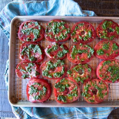 This Tomato Caprese Tart is easy to make with fresh peak season tomatoes, mozzarella cheese, and a pesto - all tucked into a tart shell. Use it for an appetizer, side dish or vegetarian dinner.