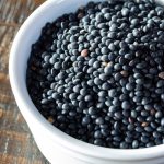 A ramekin filled with black lentils.