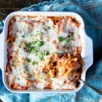 Meatball casserole with pasta in a baking dish with a spoon dishing up.