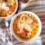 Bowls of hearty vegetable soup with white beans and chicken.