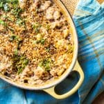 Top view of baked risotto in a Dutch oven topped with breadcrumbs and parsley.