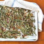 Baking sheet of roasted green beans and mushrooms.