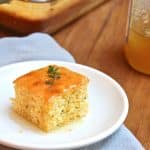 A piece of cornbread baked with thyme, topped with honey.