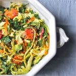 Large bowl filled with a salad of kale, cabbage and slices of blood oranges.