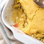 Zucchini, corn and bean casserole topped with cornbread, with a scooped out portion.