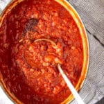 A large pot filled with a spicy tomato sauce cooked with onions and dried chipotle pepper.