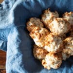 A basket lined with a napkin filled with Bisquick muffins.