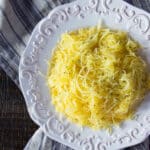 A platter of spaghetti squash cooked in the air fryer and sprinkled with freshly ground pepper.