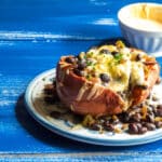 A sweet potato stuffed with black beans, onions, and cheese.