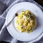 A bundle of aglio e olio spaghetti squash topped with Parmesan cheese.