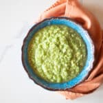 A bowl of tomatillo green-chili salsa verde with a napkin.
