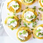 Mini chickpea pancakes topped with sour cream and scallions.