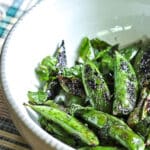 A bowl of snap peas that have been grilled and tossed with mint.