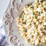 An old fashioned white bowl filled with creamy Mexican Street Corn salad.