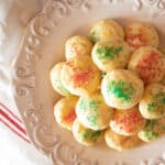 Italian Ricotta Cookies decorated for Christmas piled on a white plate.